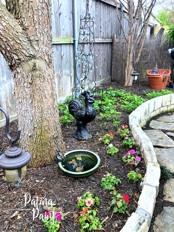 flower bed, tree, light birdbath, flowers rooster